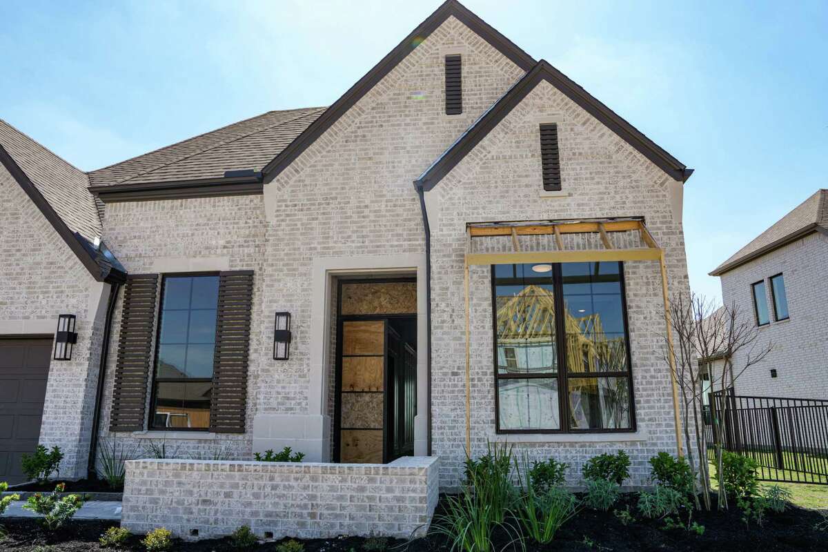 Construction is seen in the reflection of a window of a home in Prairieland Village, a Bridgeland master-planned community is photographed on Monday, March 11, 2024, in Cypress.