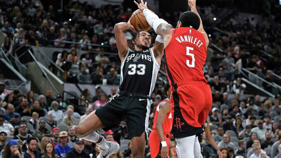 San Antonio Spurs' Tre Jones (33) goes to the basket as Houston Rockets' Fred VanVleet defends during the first half of an NBA basketball game Tuesday, March 12, 2024, in San Antonio. (AP Photo/Darren Abate)