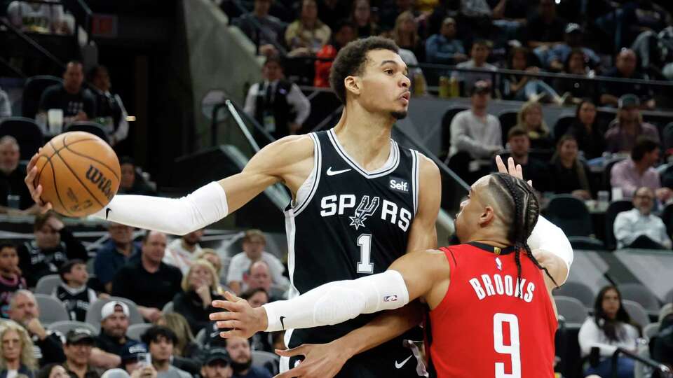 SAN ANTONIO, TX - MARCH 12: Victor Wembanyama #1 of the San Antonio Spurs looks to pass over Dillon Brooks #9 of the Houston Rockets in the second half at Frost Bank Center on March 12, 2024 in San Antonio, Texas. NOTE TO USER: User expressly acknowledges and agrees that, by downloading and or using this photograph, User is consenting to terms and conditions of the Getty Images License Agreement.