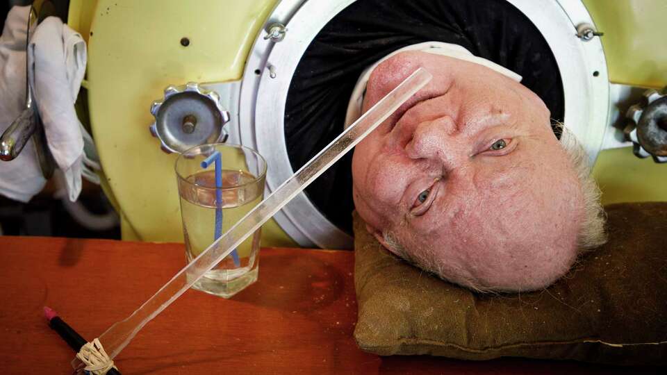 FILE - In this Friday, April 27, 2018 photo, attorney Paul Alexander looks out from inside his iron lung at his home in Dallas. Alexander died Monday, March 11, 2024 at a Dallas hospital, said Daniel Spinks, a longtime friend. He said Alexander had recently been hospitalized after being diagnosed with COVID-19 but did not know the cause of death. (Smiley N. Pool/The Dallas Morning News via AP)