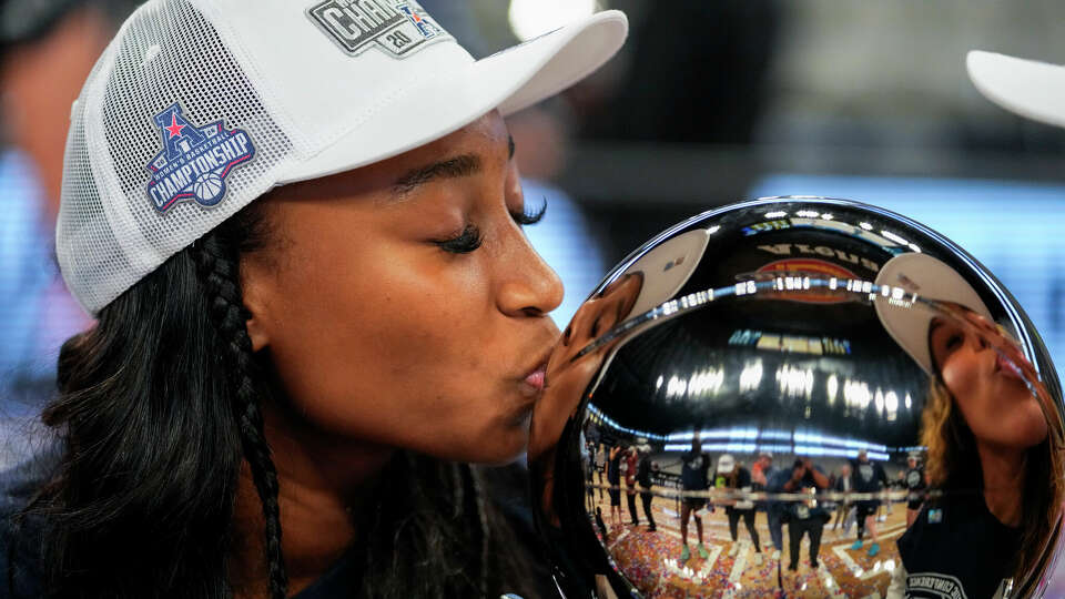 Rice's Jazzy Owens-Barnett kisses the trophy after hear team defeated East Carolina 61-41 during an NCAA college basketball game for the American Athletic Conference tournament championship, Wednesday, March 13, 2024, in Fort Worth, Texas. (AP Photo/Julio Cortez)