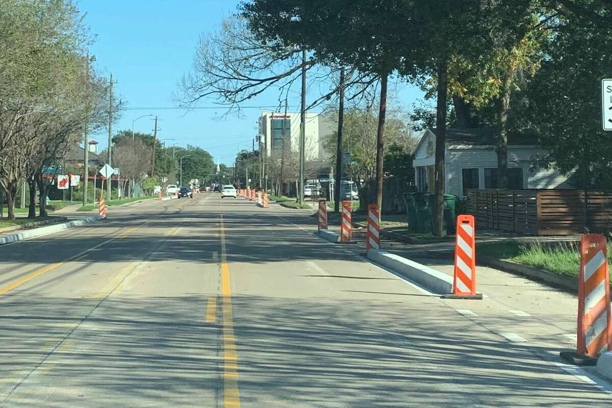 A cross section of 11th street, east of Studewood, indicating three lanes with a two-way left turn lane in the middle and curb barriers on both sides with construction posts before/after each curb barrier.