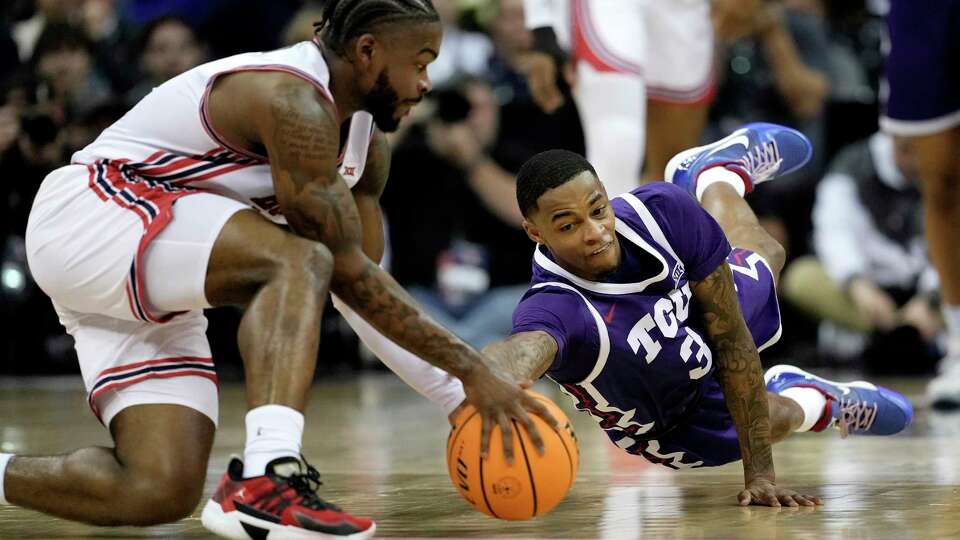 Houston guard Jamal Shead, left, and TCU guard Avery Anderson III (3) chase a loose ball during the first half of an NCAA college basketball game in the quarterfinal round of the Big 12 Conference tournament, Thursday, March 14, 2024, in Kansas City, Mo. (AP Photo/Charlie Riedel)