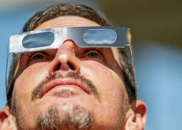 Scott Eric Schindler watches the annular solar eclipse from his backyard on October 14, 2023 in Kerrville, Texas. Eclipse glasses must be worn at all times during a partial solar eclipse. 