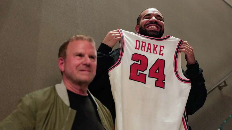 Tilman Fertitta presents Drake with a UH Basketball jersey after the mens basketball team watched the NCAA Tournament Selection Show on CBS at the Post Oak Hotel on Sunday, March 17, 2024, in Houston.