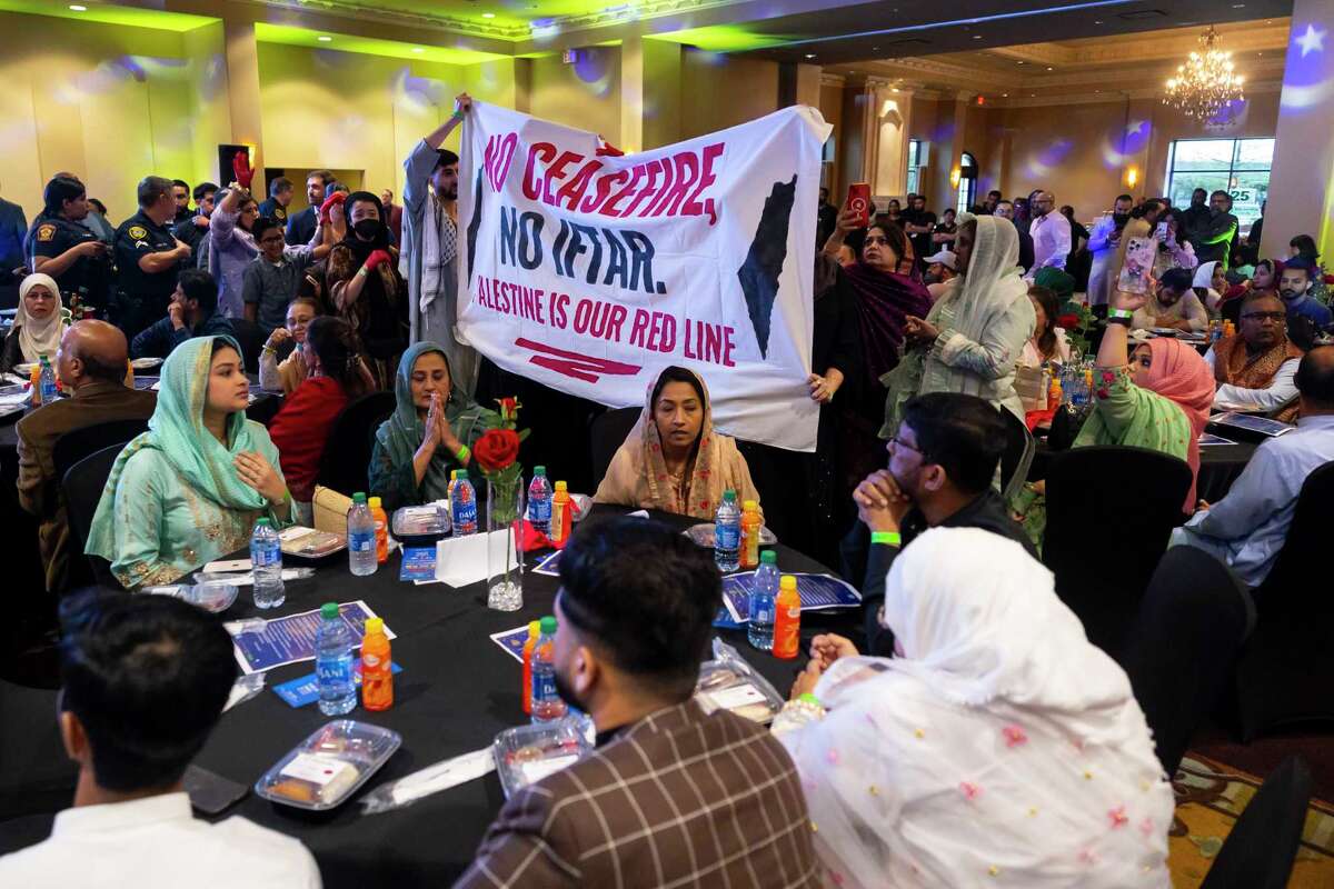 Demonstrators march through tables to demand a ceasefire during the 