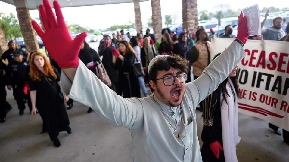 Demonstrators chant after being escorted outside by police during the 