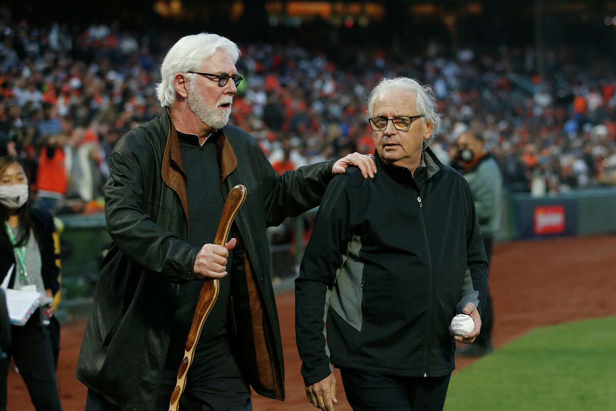 Former San Francisco Giants players and current team broadcasters Mike Krukow (left) and Duane Kuiper walk out to throw out the ceremonial first pitch before Game 1 of the NLDS between the Los Angeles Dodgers and the San Francisco Giants at Oracle Park on Friday, October 8, 2021 in San Francisco.