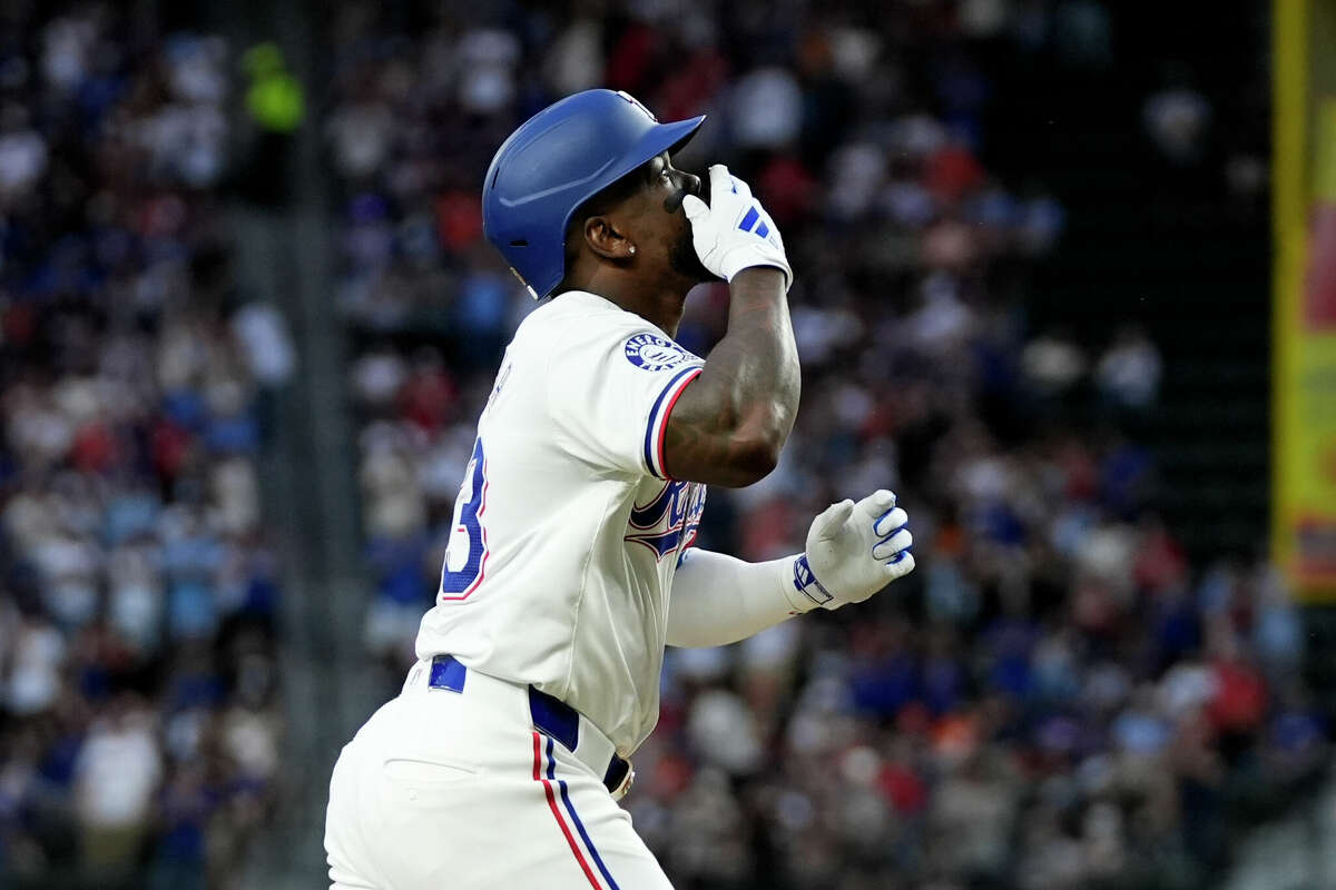 Texas Rangers' Adolis García celebrates his three-run home run as he jogs home in the second inning of a baseball game against the Houston Astros in Arlington, Texas, Friday, April 5, 2024.