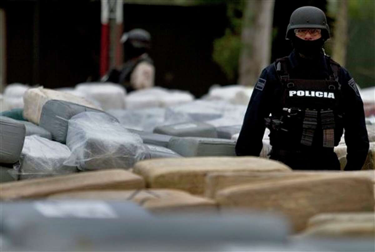 A police officer guards packages of seized marijuana during a presentation for the media in Tijuana, Mexico, Monday, Oct. 18, 2010. On a conjoined operation with the army, local and state police seized 105 tons of U.S.-bound marijuana Monday, by far the biggest drug bust in the country in recent years. Eleven suspects were detained. (AP Photo/Guillermo Arias)