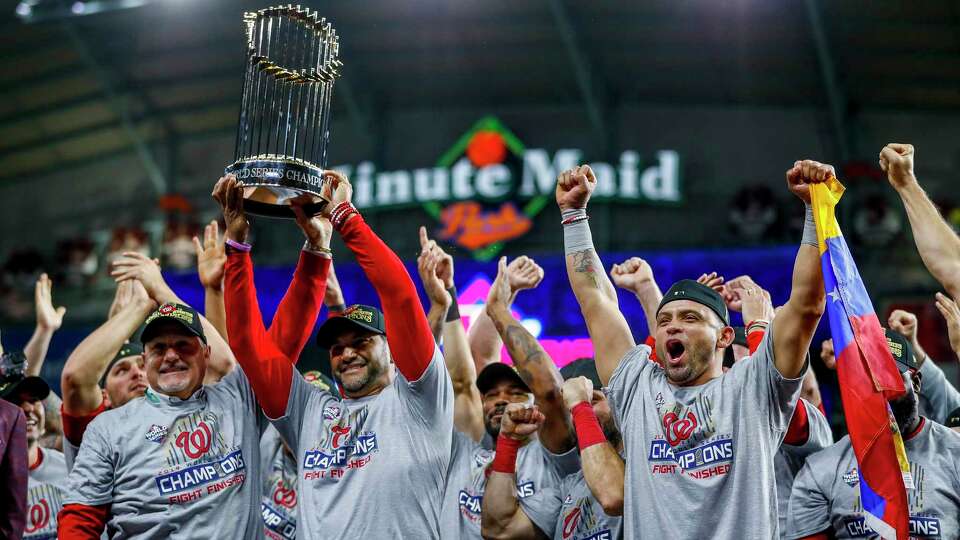 Washington Nationals manager Dave Martinez (4) holds the Commissioners Trophy after the Nationals won Game 7 of the World Series at Minute Maid Park on Wednesday, Oct. 30, 2019, in Houston.