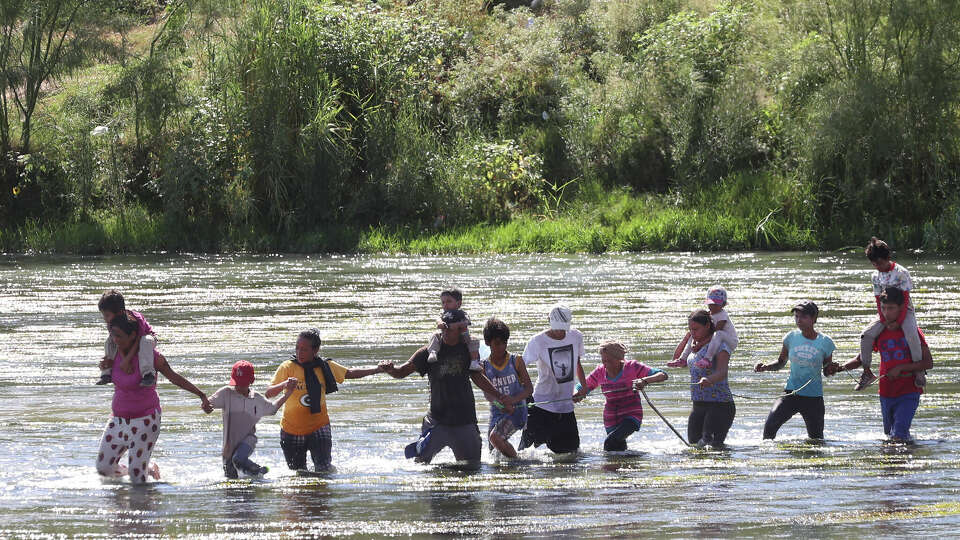 A group of migrants cross the Rio Grande at Eagle Pass, Texas, Thursday, Sept. 21, 2023. A surge of migrants started early in the week and continued through Thursday.
