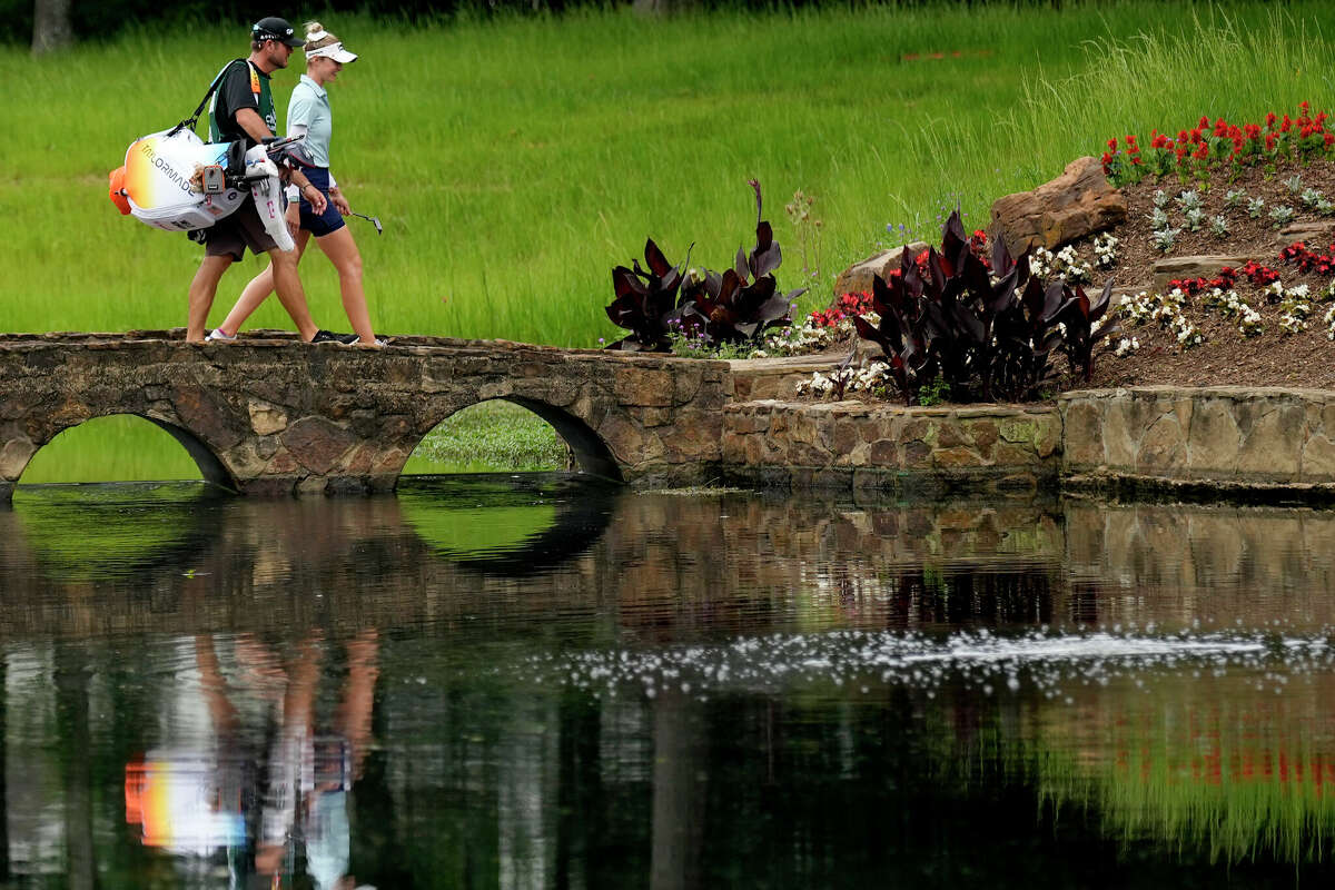 Nelly Korda and he caddie walk across the 15th fairway bridge during the second round of the Chevron Championship LPGA golf tournament Friday, April 19, 2024, at The Club at Carlton Woods, in The Woodlands, Texas.