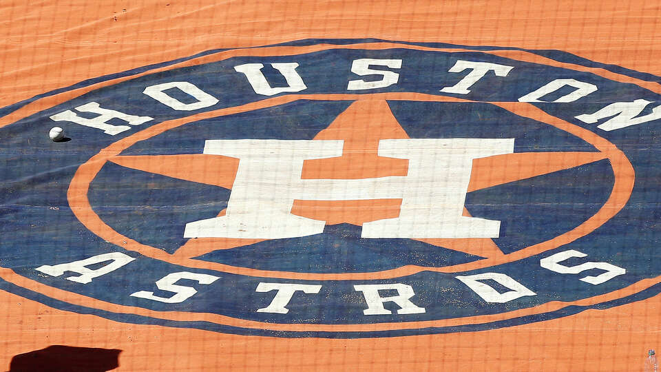 Players and staff walk by the Houston Astros logo on the field during workouts at Minute Maid Park, Thursday, October 11, 2018, in Houston, as the Astros prepare to leave for Boston for the ALCS.