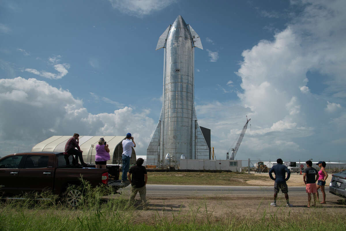 Space enthusiasts look at a prototype of SpaceX's Starship spacecraft at the company's Texas launch facility on September 28, 2019 in Boca Chica near Brownsville, Texas. 