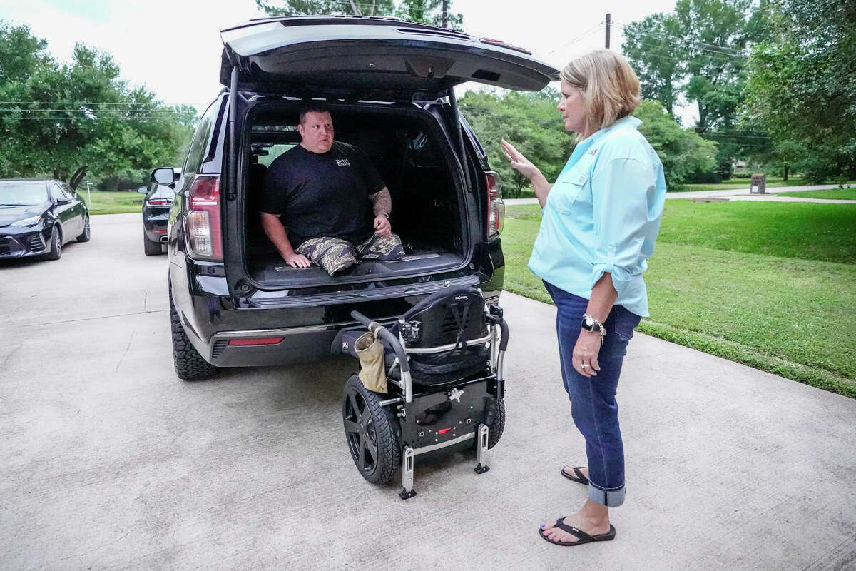 Daniel Peterson demonstrates how he is able to get into his vehicle, after Gina Skinner, through the Joshua Chamberlain Society, made the downpayment for the vehicle, while during a visit at his home on Thursday, April 25, 2024, in Tomball. Since 2019, Magnolia ISD math teacher Gina Skinner has worked alongside her husband running a local chapter of the Joshua Chamberlain Society, a National organization that assists post-9/11 combat wounded veterans. The Skinners work to help disabled veterans through fundraisers and assisting them around their homes. Former Marine, Daniel Peterson lost his legs to an IUD.