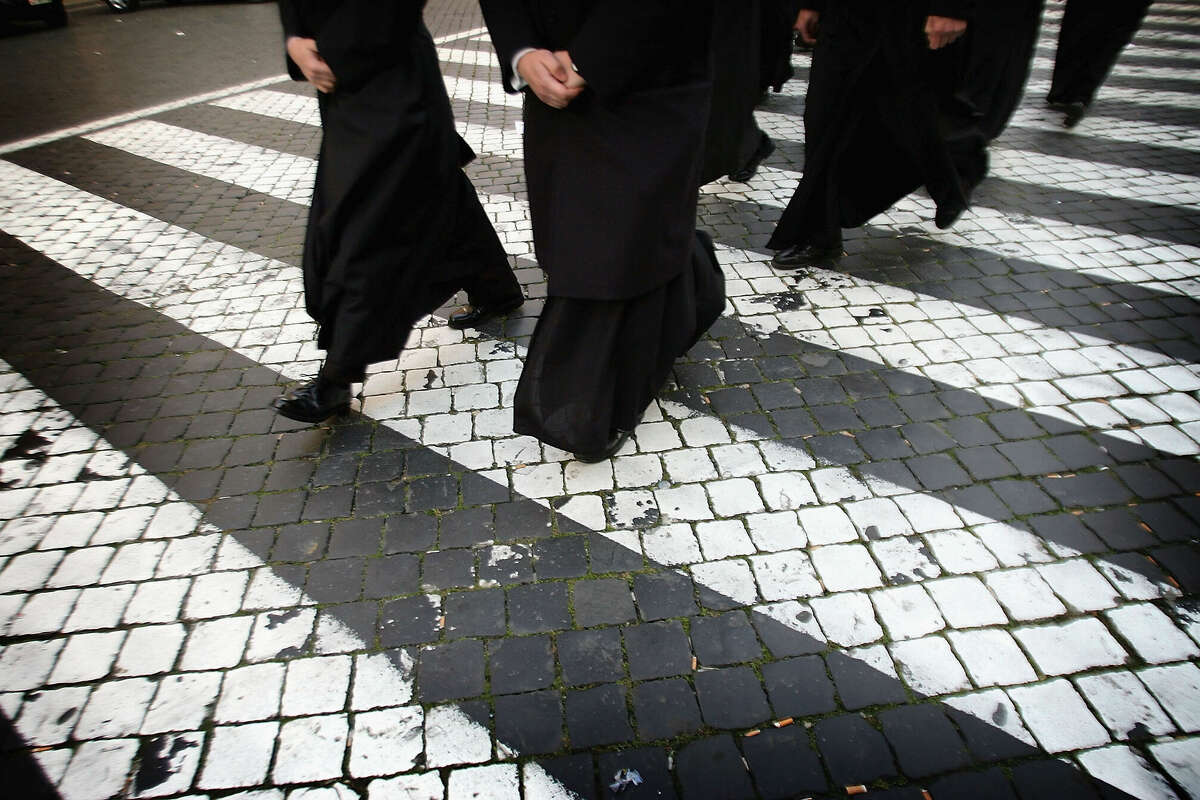 Priests make their way to wait in line to view the body of Pope John Paul II as it lays in state in the St Peter's Basilica April 5, 2005 in Vatican City. The Pope's body will be viewed by the faithfull in the Basilica until the funeral ceremony April 8.