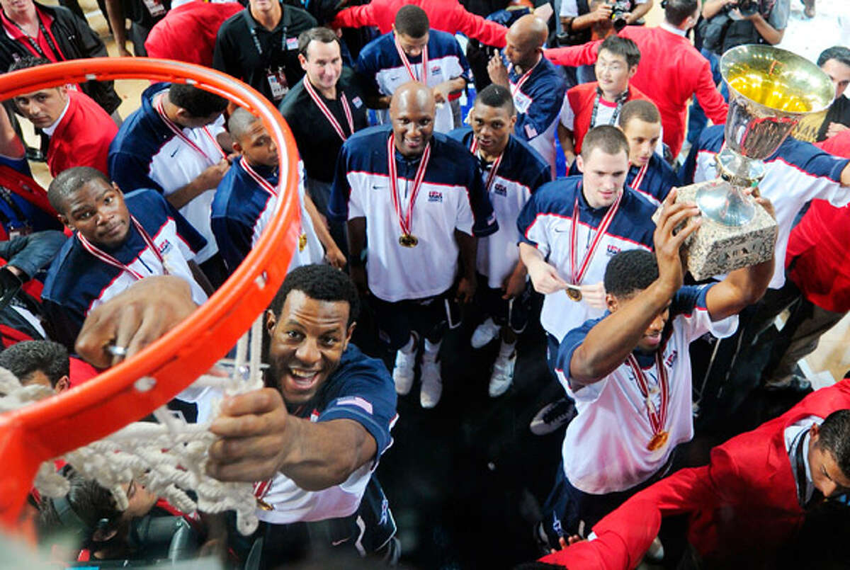 Team USA's Andre Iguodala cuts a piece of the net as teammates and coaches look on Sunday in Istanbul.