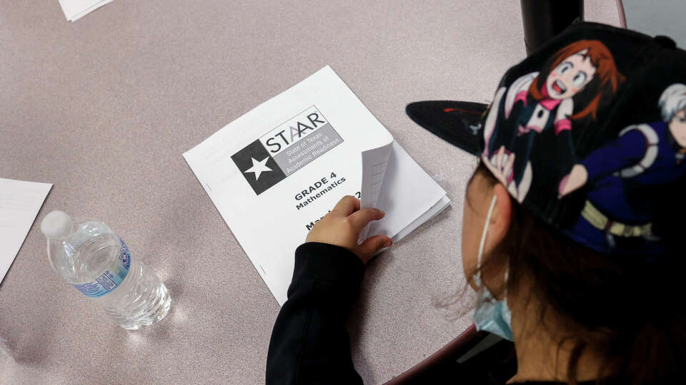 A fourth grader flips open her STAAR mathematics booklet to go over her answers during class at Heritage Elementary School in San Antonio, Texas, on March 3, 2022. Superintendent Ramirez visited the school as part of his ongoing teacher assessments and mock testing evaluations.