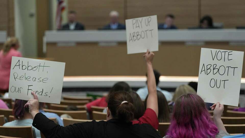 Cy-Fair ISD parents hold signs to share their concerns about the most recent budget cuts, which included librarians, during the school boards’ workshop meeting at the Mark Henry Administration Building on Thursday, May 2, 2024 in Cypress.