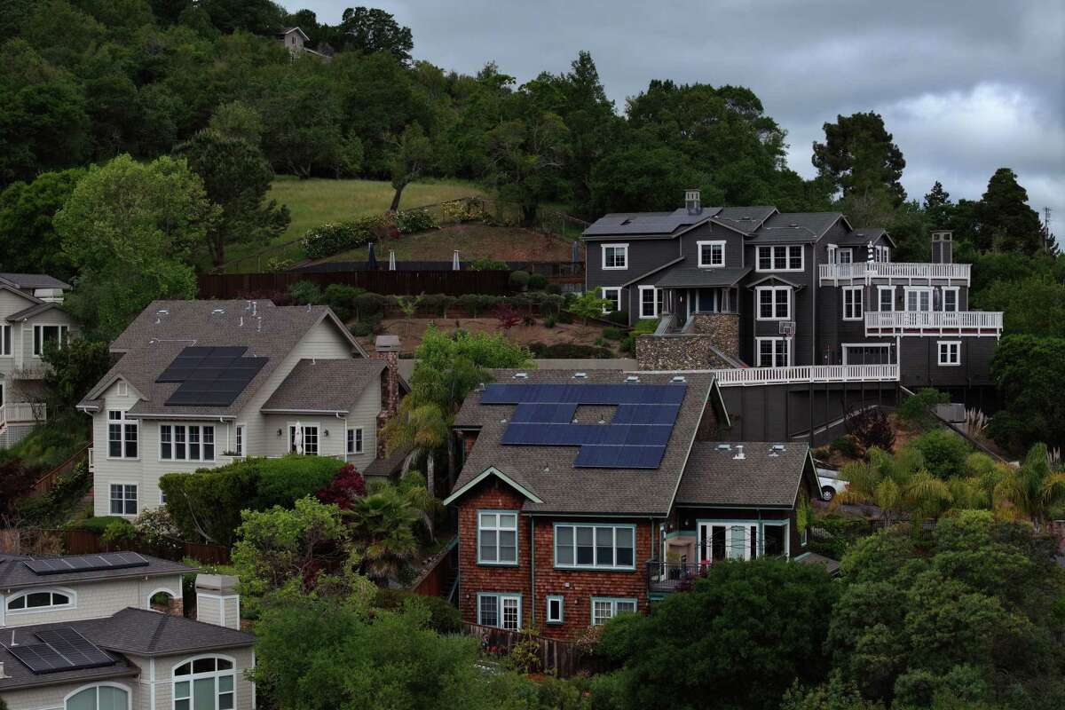 SAN RAFAEL, CALIFORNIA - APRIL 25: In an aerial view, solar panels are seen on the roofs of homes in a neighborhood on April 25, 2024 in San Rafael, California. California has cut back on rooftop solar incentives as the state has an estimated 47 gigawatts of solar power installed, nearly 25 percent of the state's electricity, that powers 13.9 million homes. On days where there is little demand for electricity, the price of electricity flattens and gigawatts of the solar generated power is curtailed.