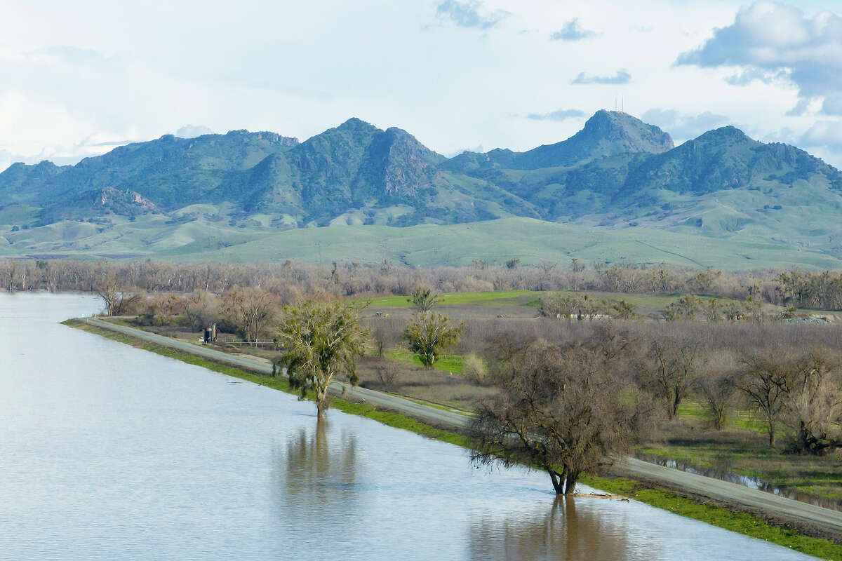 A drone view of floodwaters from the Sacramento River moved through the Colusa Bypass downstream from the Colusa Weir, shown in the background is the Sutter Buttes, in Colusa County, California, February 6, 2024.