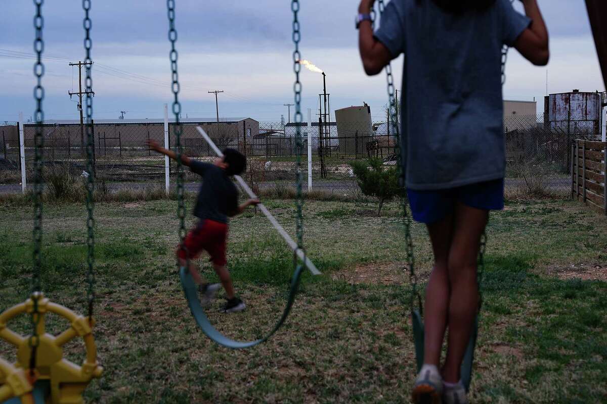 A flare burns near Vanessa and Victor Hinojos' home as their children play in the backyard on Wednesday, March 6, 2024 in Odessa. on Wednesday, March 6, 2024 in Odessa.