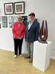 Donna and Gene Smith stand beside a sculpture called "Spot On," by Gene Smith, at The Grafton Art Gallery May 6, 2024. The wood, called purple heart, from Knotty by Nature Hardwood in Grafton, is buffed to a sheen that required no stain. The statue stands on a slab of rock from the Smiths' yard. The Smiths are standing in front of a collection by Lou Ann Branz, who has built a strong following exhibiting at Jacoby Arts Center and Mississippi Mud Pottery, both in Alton.  Donna and Gene Smith stand beside a sculpture called "Spot On," by Gene Smith, at The Grafton Art Gallery May 6, 2024. The wood, called purple heart, from Knotty by Nature Hardwood in Grafton, is buffed to a sheen that required no stain. The statue stands on a slab of rock from the Smiths' yard. The Smiths are standing in front of a collection by Lou Ann Branz, who has built a strong following exhibiting at Jacoby Arts Center and Mississippi Mud Pottery, both in Alton.