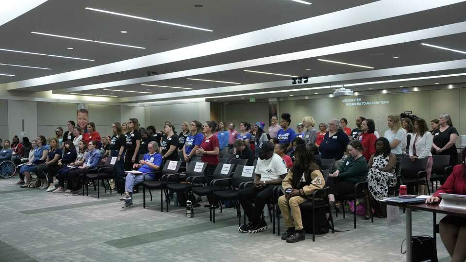 Community members and teachers stand in support of a speaker who is also a recently terminated teacher during Houston ISD's Board of Managers monthly board meeting on Thursday, May 9, 2024, in Houston.