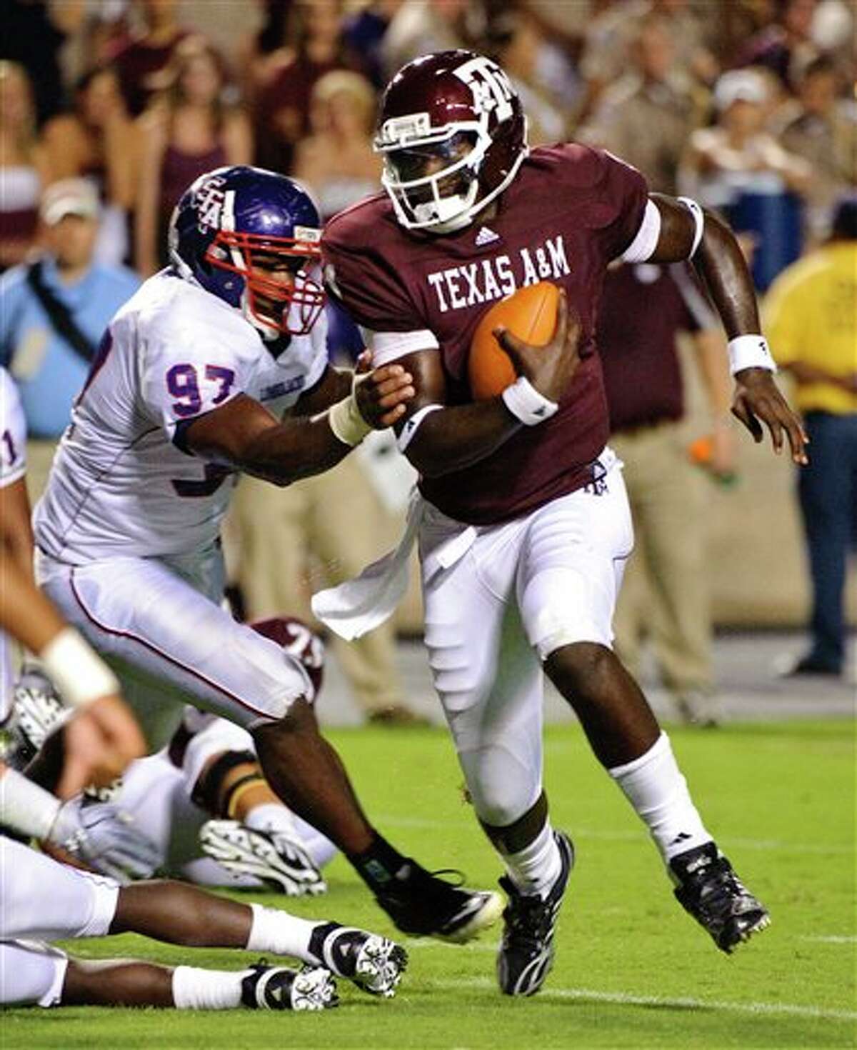 Texas A&M quarterback Jerrod Johnson (right) tries to pull away from Stephen F. Austin's Kenneth Charles.