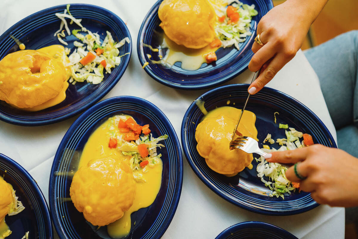 A customer cuts into a puffy queso at Los Tios Mexican Restaurant in Houston, Texas.