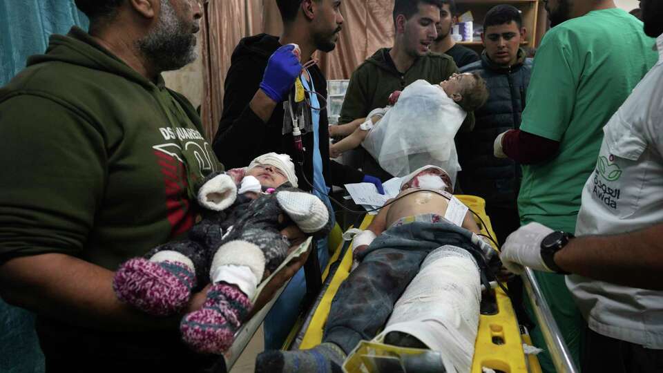 Palestinian children wounded in the Israeli bombardment of the Gaza Strip are brought to the hospital in Deir al Balah, Gaza Strip, on Monday, Dec. 11, 2023. (AP Photo/Adel Hana)