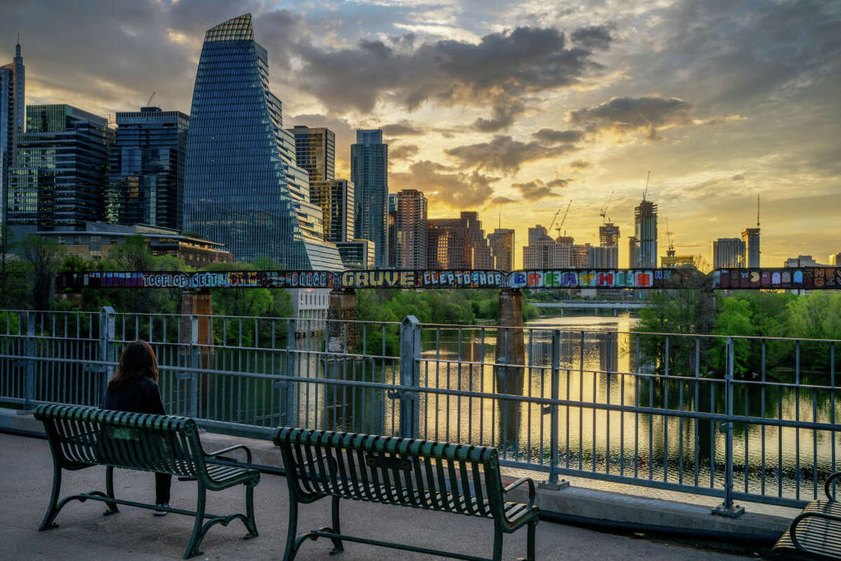 A person watches the sunrise over the downtown skyline on March 19, 2024 in Austin, Texas. From peaking in 2022, home prices and apartment rents in Austin, Texas, have declined more than any other city in the country in 2024. 