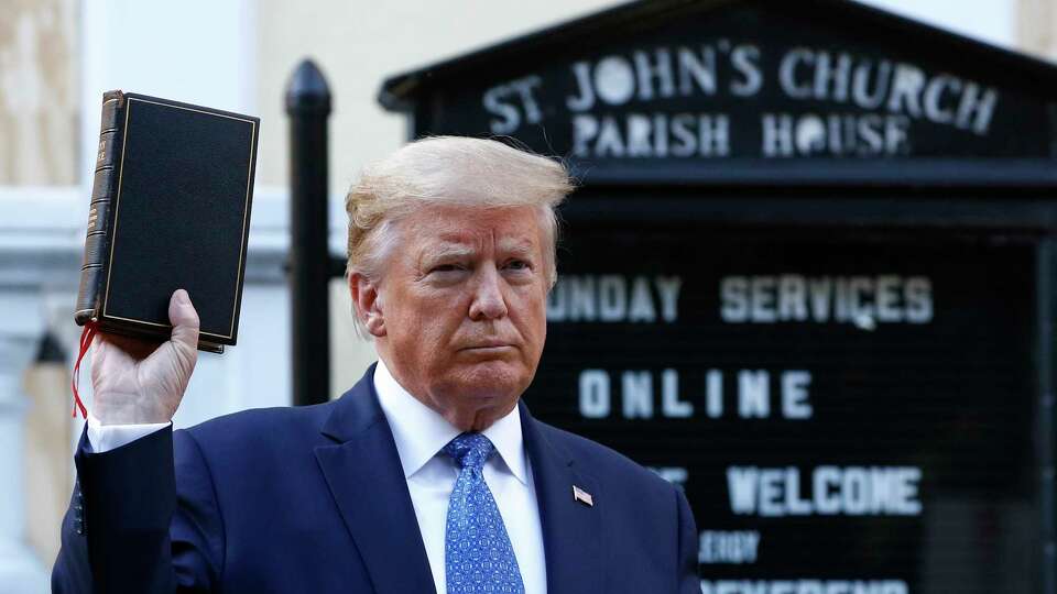 FILE - In this Monday, June 1, 2020 file photo, President Donald Trump holds a Bible as he visits outside St. John's Church across Lafayette Park from the White House in Washington. Part of the church was set on fire during protests the previous night. (AP Photo/Patrick Semansky)