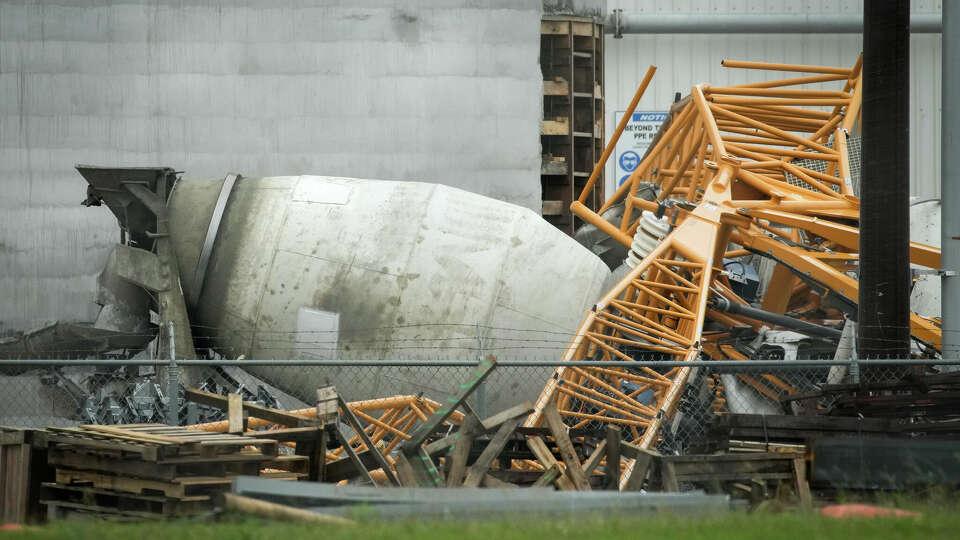A crane sits on top of a cement truck at an address where authorities say a man was killed when a crane fell on the cement truck he was sitting in during the previous night's storm Friday, May 17, 2024, in Houston. (Jon Shapley/Houston Chronicle)