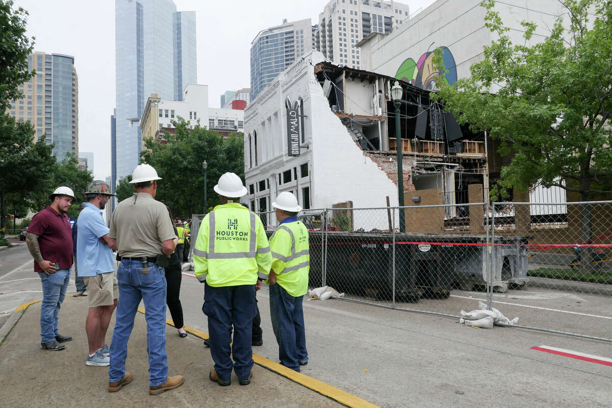 Workers survey damage in Downtown Houston after severe storms blew through Thursday.