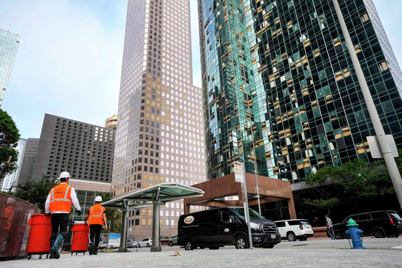 Workers clean up debris downtown on Monday, May 20, 2024 in Houston. The city closed off streets in a six-block exclusion zone downtown, from McKinney to Polk and from Smith to Travis, as workers continued to clean up broken glass from downtown streets and windows.