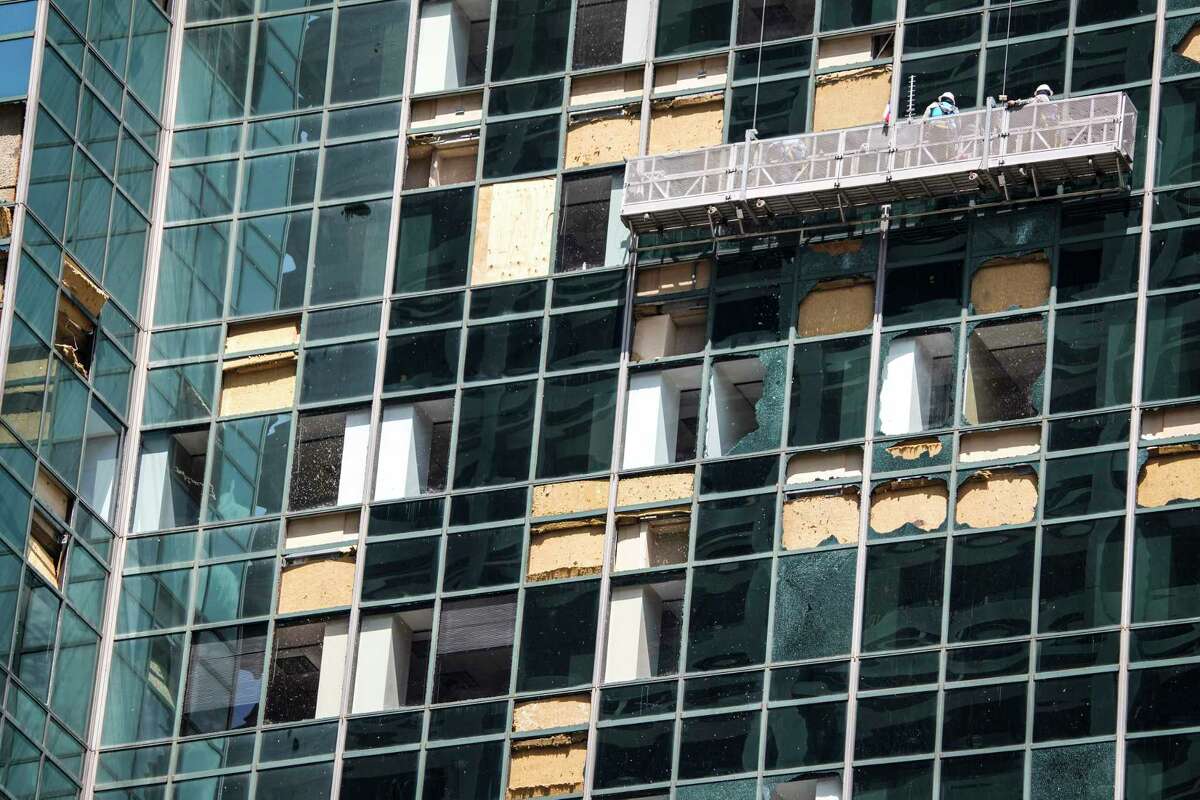 Workers clean out shattered glass at the Wells Fargo building as clean up from last week's storm continues downtown on Monday, May 20, 2024 in Houston. The city closed off streets in a six-block exclusion zone downtown, from McKinney to Polk and from Smith to Travis to ease traffic around the area where broken glass and debris are prevalent.