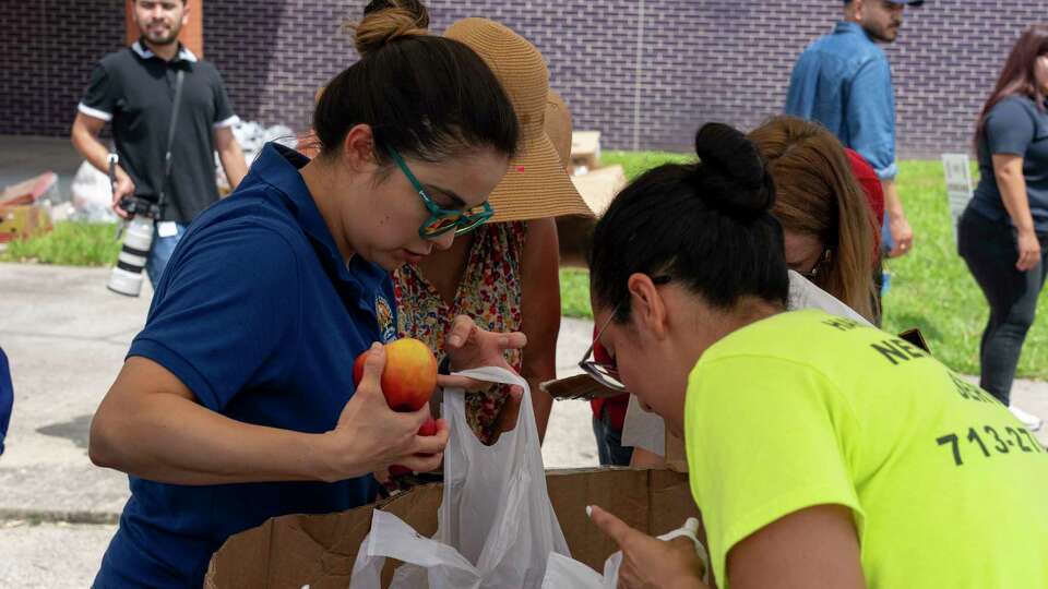 Volunteers bag up fresh fruit at Moody Park Community Center to be distributed with dry foods, water and ice to residents following severe storms that passed through the area Thursday.