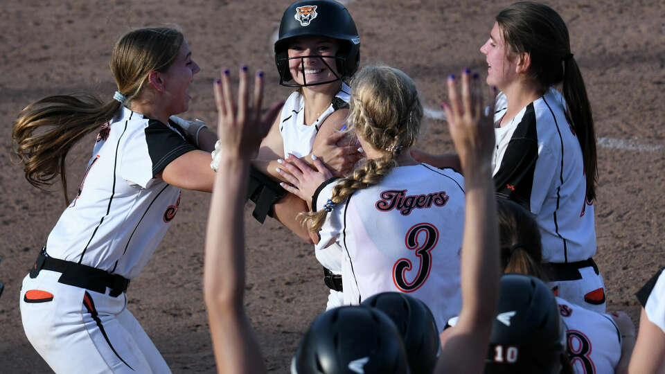 Ridgefield's Maddie Pickett is swarmed by her teammates after winning the game with a walkoff hit during the FCIAC softball semifinals between Ridgefield and Norwalk at Fairfield University, Fairfield on Monday, May 20, 2024.