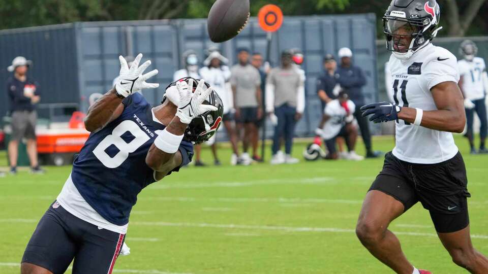 Houston Texans wide receiver John Metchie looks over his shoulder to track a ball thrown to him against cornerback Jeff Okudah (11) during an NFL football OTA practice on Tuesday, May 21, 2024, at Houston Methodist Training Center in Houston.