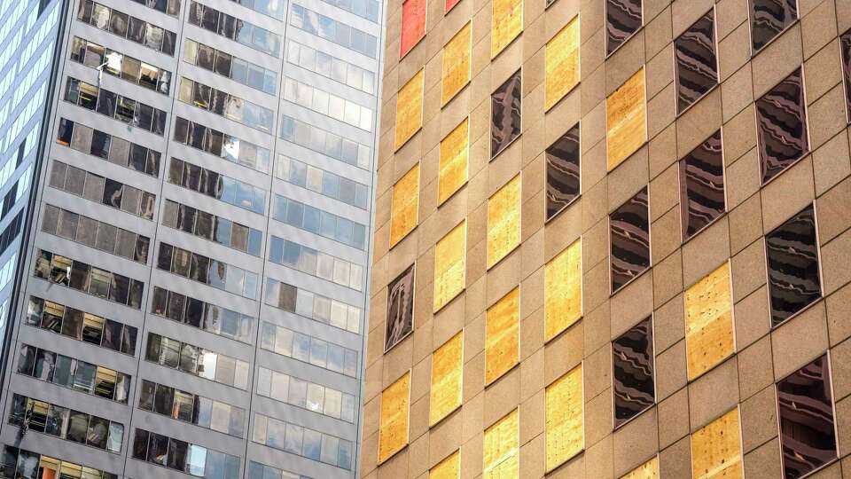 Boarded up windows on the Enterprise Plaza building’s blown out windows downtown on Wednesday, May 22, 2024, in Houston, after a strong thunderstorm moved through last Thursday evening.