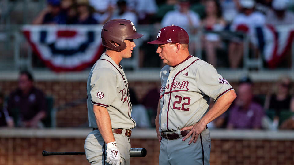 Texas A&M baseball coach Jim Schlossnagle (22) speaks with Ryan Targac while the TCU infield meets on the mound during an NCAA college baseball tournament regional game against TCU Sunday, June 5, 2022, in College Station, Texas. (Meredith Seaver/College Station Eagle via AP)