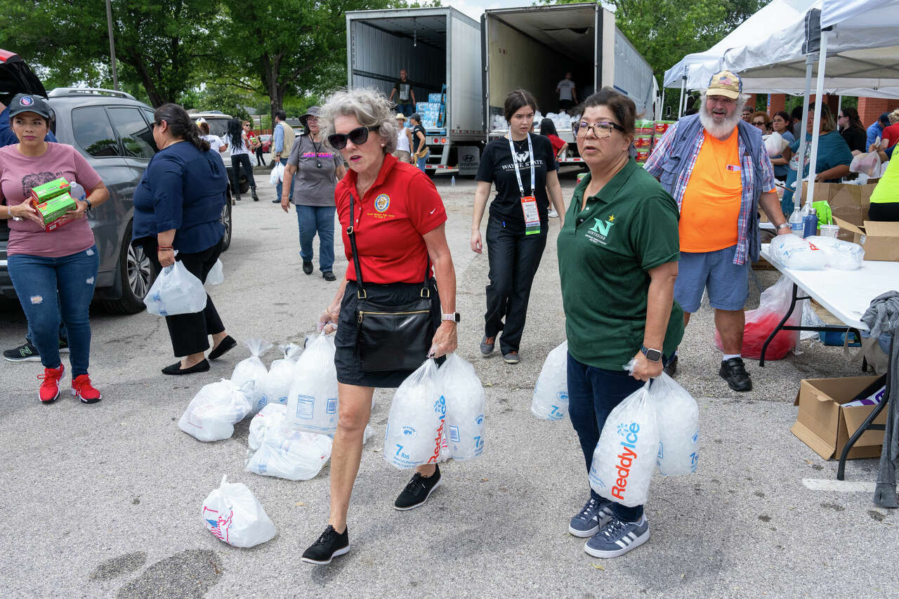 Houston city council member Twilla Carter, center, and other volunteers carry bags of ice to a car at Moody Park Community Center with other volunteers carrying dry foods, fresh fruits, and water to residents following severe storms that passed through the area last Thursday.