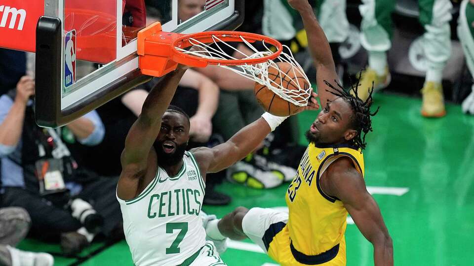 Boston Celtics guard Jaylen Brown (7) dunks the ball against Indiana Pacers forward Aaron Nesmith (23) during the first quarter of Game 1 of the NBA Eastern Conference basketball finals, Tuesday, May 21, 2024, in Boston.