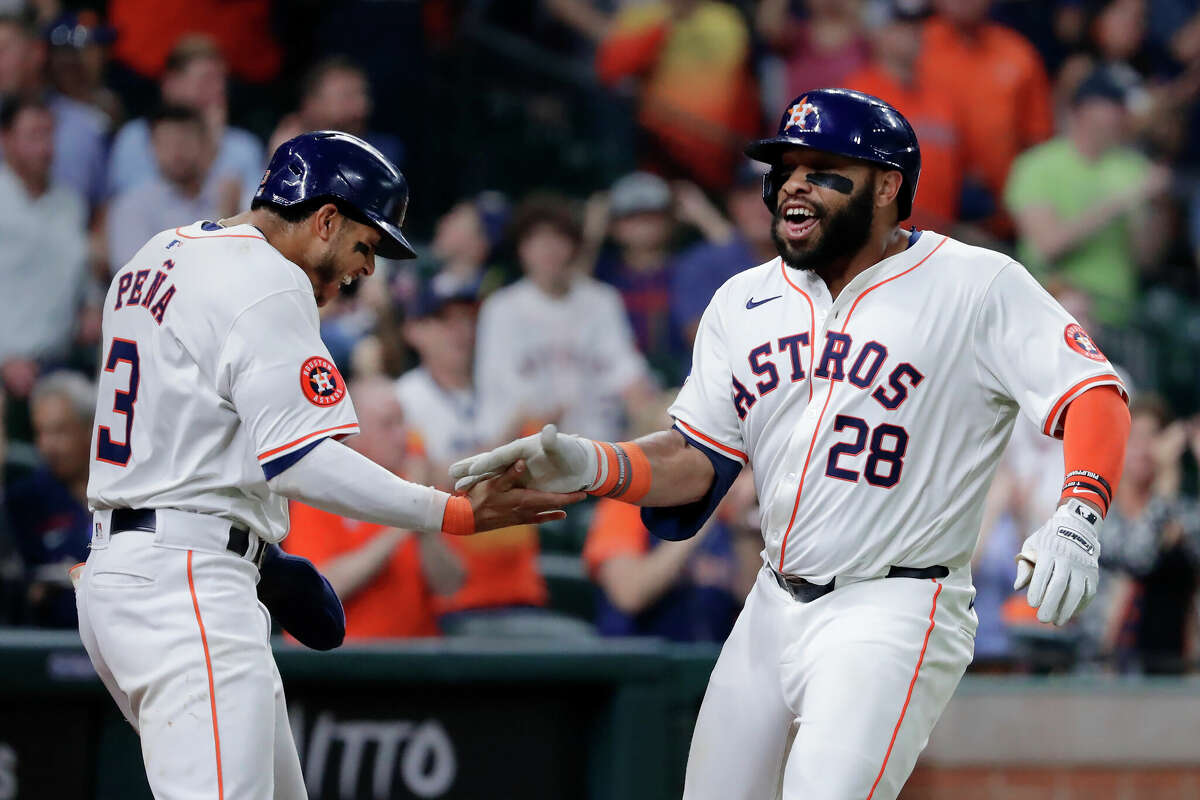 Houston Astros' Jeremy Pena (3) and Jon Singleton (28) celebrate after the both score on a two-run home run by Singleton against the Los Angeles Angels during the sixth inning of a baseball game Tuesday, May 21, 2024, in Houston.