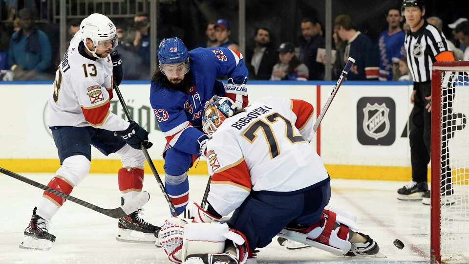 Florida Panthers goaltender Sergei Bobrovsky (72) deflects a shot by New York Rangers center Mika Zibanejad (93) as Florida Panthers center Sam Reinhart (13) looks for the rebound during the second period of Game 1 of the NHL hockey Eastern Conference Stanley Cup playoff finals, Wednesday, May 22, 2024, in New York.