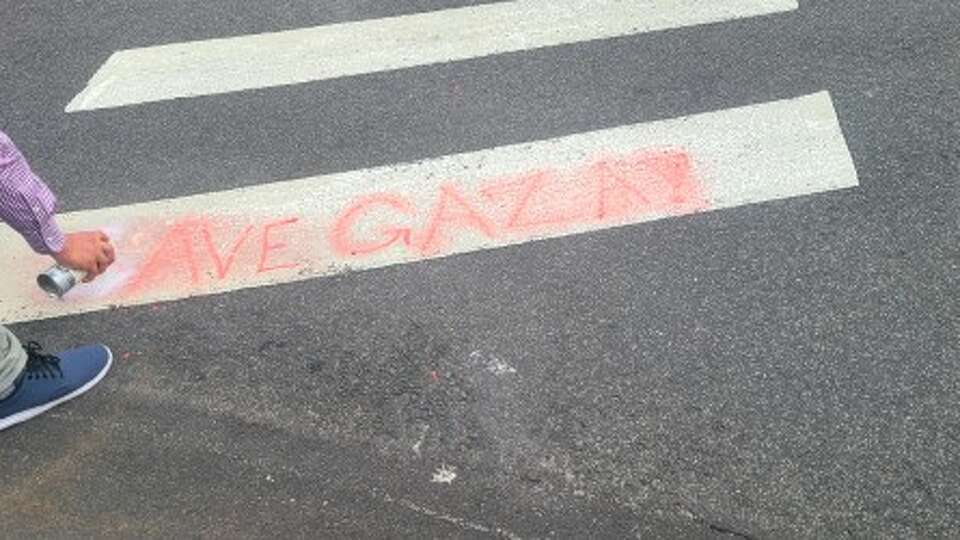 Westport police charged a woman after she spray-painted 'Save Gaza' on a crosswalk on Post Road East and Main Street Thursday evening. The town's Highway Department addressed the mater Friday, police said. 