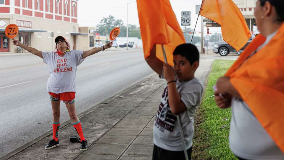 Jan Welch, left, of Austin, holds up two homemade fans that read 