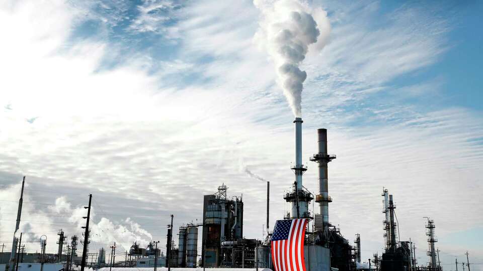 FILE - A flag hangs on the side of the Andeavor Mandan Refinery in Mandan, N.D., Sept. 6, 2017. Nineteen Republican state attorneys general have asked the U.S. Supreme Court to get involved in a dispute over climate-change lawsuits.